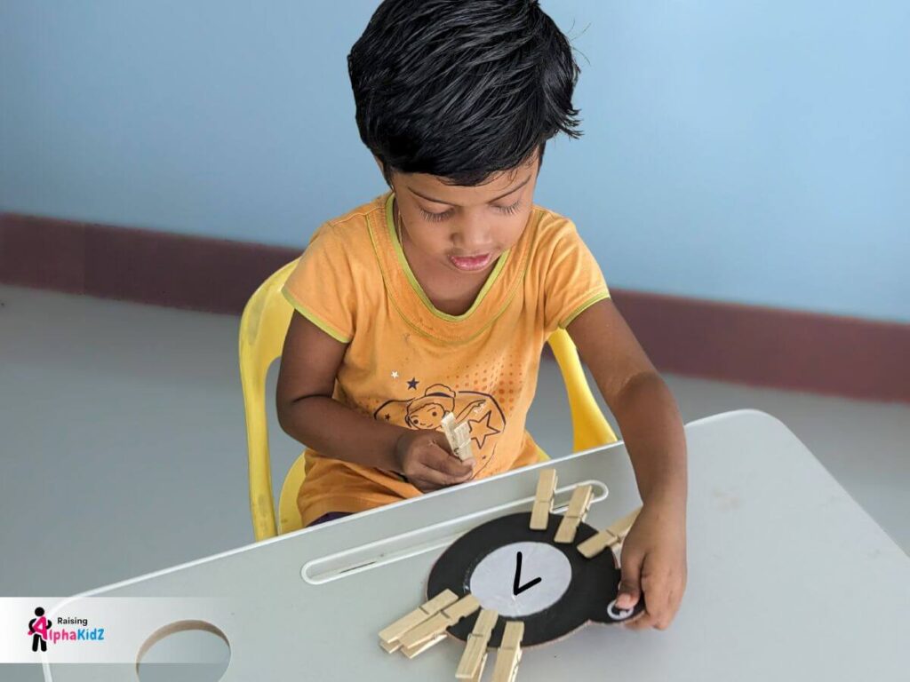 Child clipping clothespin legs to a paper spider for counting activity