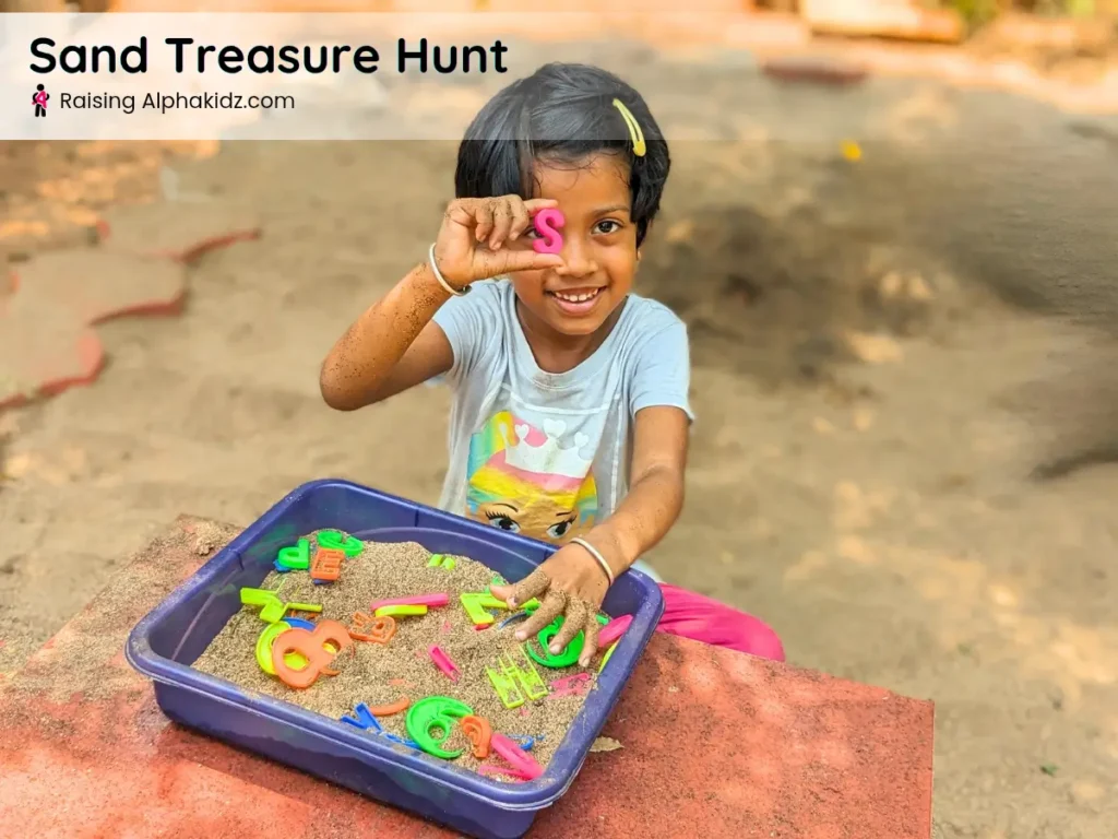 kid finding alphabet letter on sand tray during sand treasure hunt