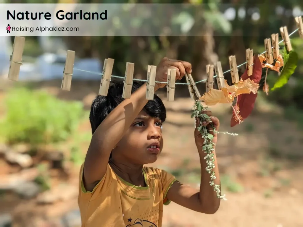 kid clipping leaves and flowers to a string for making a nature garland activity