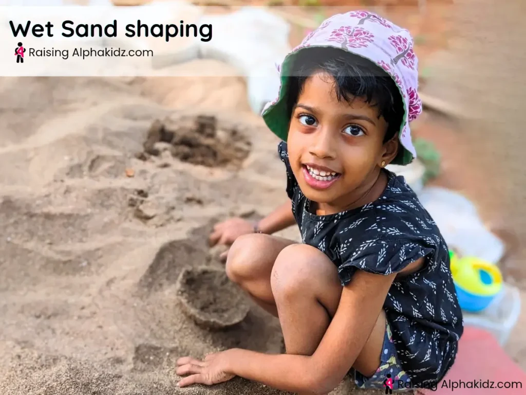 kid shaping a sand bowl using water in sand play activity