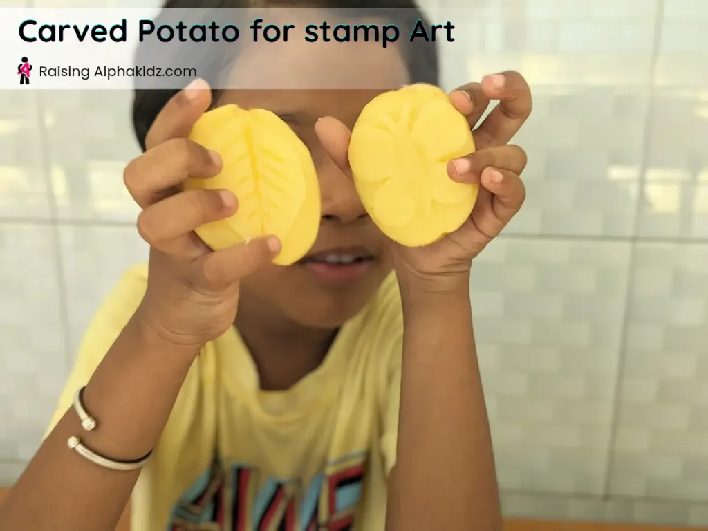 kid holding leaf and butterfly potato stamp art made from carved potato halves