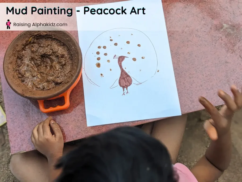 kid making fingerprint mud dots on peacock feathers for mud painting