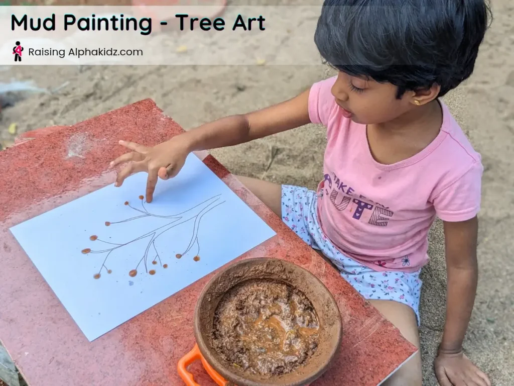 kid making mud dots on tree outline for mud painting