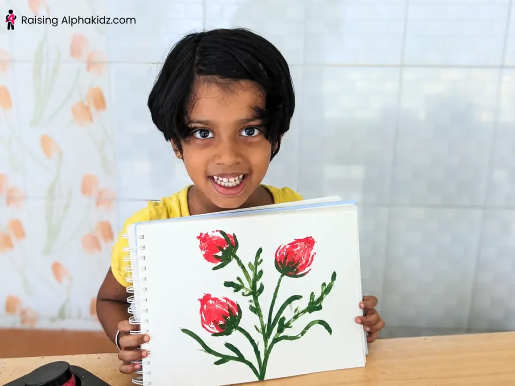 child holding finished onion stamp art flower painting made with onion printing