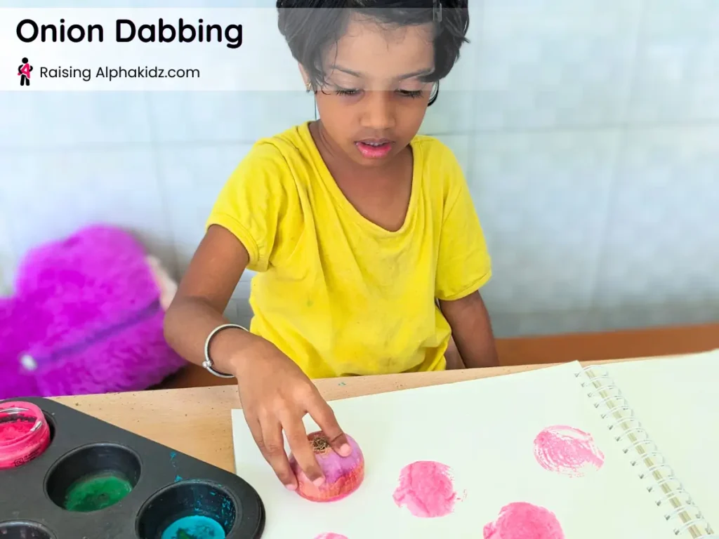 child creating onion stamp art with onion dabbing and vegetable printing activity