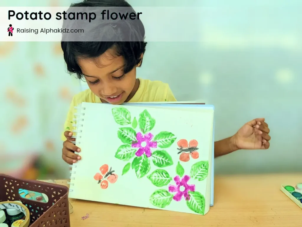 child showing the finished potato stamp flower art project