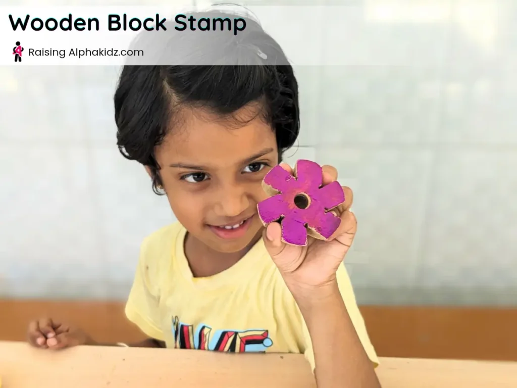 kid showing floral wood block used for potato stamp art