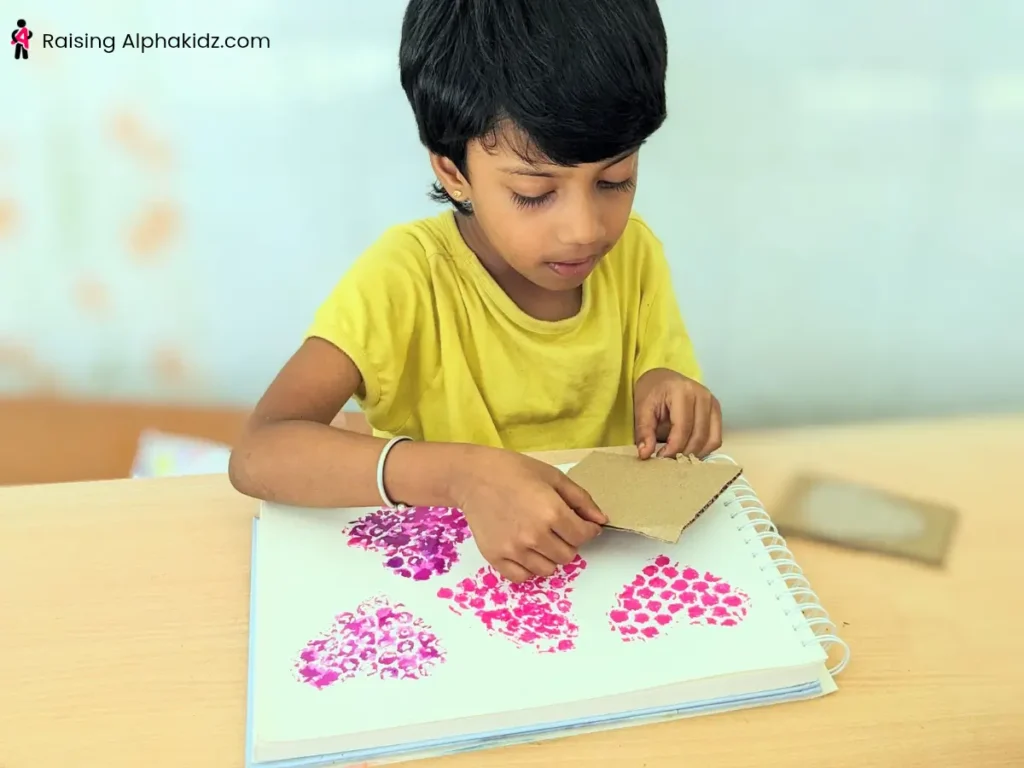 A kid making heart Prints using bubble wrap stamps
