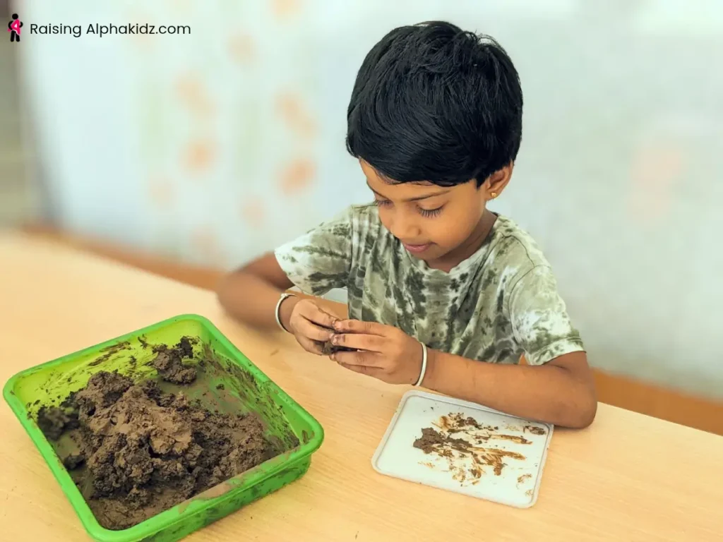 Terracotta clay being mixed with water to prepare for modeling 