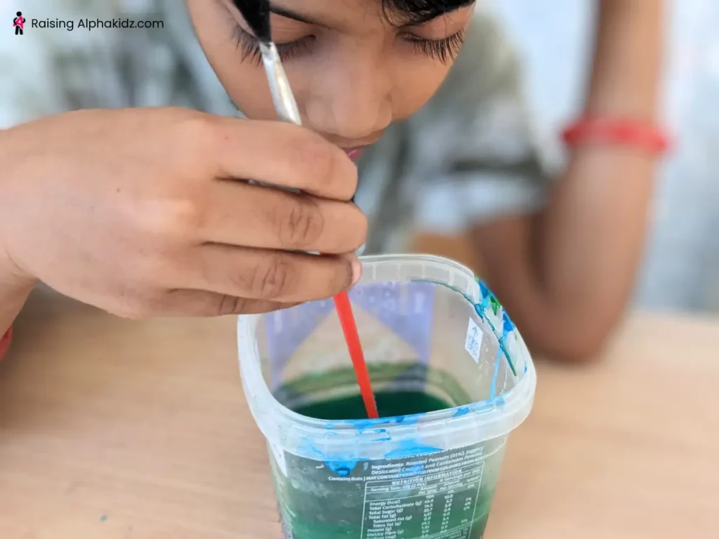 Kid mixing soap and paint to create soap bubble art