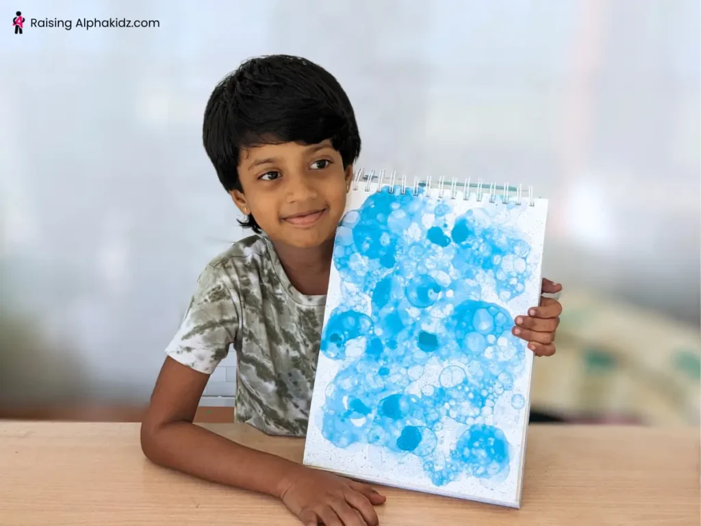 Kid displaying soap bubble art made with dish soap